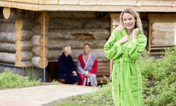 Frau im grünen Bademantel im Saunabereich